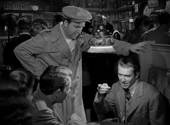Movie still from “Harvey” (1950), directed by Henry Koster – A group of men sitting around a table; Medium shot, Over the shoulder angle