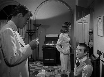 Movie still from “Harvey” (1950), directed by Henry Koster – A group of people standing around a table; Medium shot, Over the shoulder angle