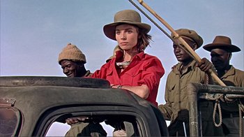 Movie still from “Hatari!” (1962), directed by Howard Hawks – A group of people standing next to each other on top of a car; Medium shot, Low angle