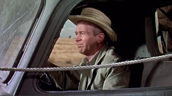 Movie still from “Hatari!” (1962), directed by Howard Hawks – A man wearing a straw hat driving a truck; Medium shot, Low angle