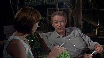 Movie still from “Hatari!” (1962), directed by Howard Hawks – A man and a woman sitting on a bench; Medium shot, Over the shoulder angle