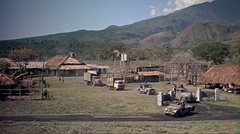 Movie still from “Hatari!” (1962), directed by Howard Hawks – An open field with several vehicles parked in it; Extreme Wide shot, High angle