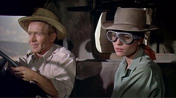 Movie still from “Hatari!” (1962), directed by Howard Hawks – A man and a woman sitting in a vehicle; Close Up shot, Over the shoulder angle