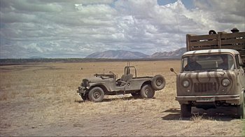 Movie still from “Hatari!” (1962), directed by Howard Hawks – An old military truck is parked in the middle of a field; Wide shot, Low angle