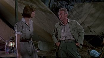Movie still from “Hatari!” (1962), directed by Howard Hawks – A man and a woman standing next to each other; Medium shot, Over the shoulder angle