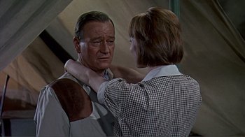 Movie still from “Hatari!” (1962), directed by Howard Hawks – An older man and a younger woman are looking at each other; Medium shot, Over the shoulder angle