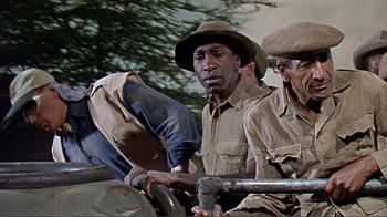 Movie still from “Hatari!” (1962), directed by Howard Hawks – A group of men sitting on top of a truck; Medium shot, Low angle