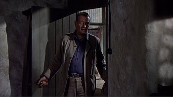 Movie still from “Hatari!” (1962), directed by Howard Hawks – An older man is walking through a doorway; Medium shot, Low angle
