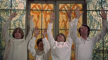 Movie still from “Head” (1968), directed by Bob Rafelson – A group of people standing next to each other with their hands up; Medium shot, Low angle