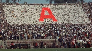 Movie still from “Head” (1968), directed by Bob Rafelson – A crowd of people standing on top of a field; Extreme Wide shot, Overhead angle