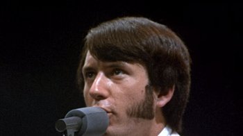 Movie still from “Head” (1968), directed by Bob Rafelson – A person holding a microphone; Close Up shot, Low angle