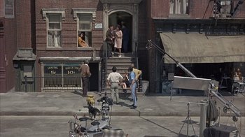 Movie still from “Head” (1968), directed by Bob Rafelson – A group of people standing on the steps of a building; Wide shot, High angle