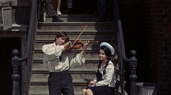 Movie still from “Head” (1968), directed by Bob Rafelson – A man and a woman playing violin on steps; Medium shot, High angle