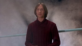 Movie still from “Head” (1968), directed by Bob Rafelson – A man wearing a sweater standing in front of a window; Medium shot, Low angle