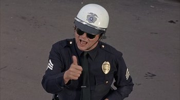 Movie still from “Head” (1968), directed by Bob Rafelson – A police officer giving a thumbs up sign; Close Up shot, Low angle