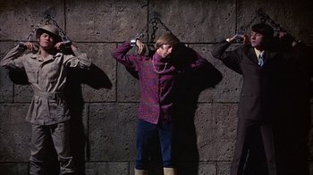 Movie still from “Head” (1968), directed by Bob Rafelson – A group of people chained to a wall; Medium shot, Overhead angle