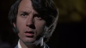 Movie still from “Head” (1968), directed by Bob Rafelson – A person wearing a suit and tie; Close Up shot, Low angle