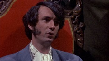 Movie still from “Head” (1968), directed by Bob Rafelson – A person wearing a suit and tie; Close Up shot, Low angle