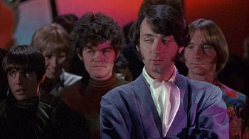 Movie still from “Head” (1968), directed by Bob Rafelson – A group of people sitting in a room; Medium shot, Low angle