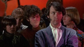 Movie still from “Head” (1968), directed by Bob Rafelson – A man in a suit and tie standing next to another man in a suit and tie; Medium shot, Low angle