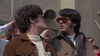 Movie still from “Head” (1968), directed by Bob Rafelson – Two men are standing next to each other and talking; Close Up shot, Over the shoulder angle