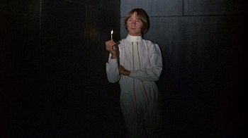 Movie still from “Head” (1968), directed by Bob Rafelson – A woman holding a lit candle in a dark room; Medium shot, Low angle