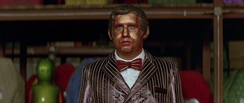 Movie still from “Heartbeeps” (1981), directed by Allan Arkush – A man in a suit and tie with makeup on his face; Close Up shot, Low angle