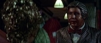 Movie still from “Heartbeeps” (1981), directed by Allan Arkush – A statue of a man wearing a suit; Close Up shot, Over the shoulder angle