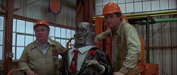 Movie still from “Heartbeeps” (1981), directed by Allan Arkush – A man in an orange hard hat is standing next to a man in a suit; Medium shot, Low angle