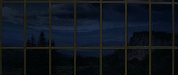 Movie still from “Heartbeeps” (1981), directed by Allan Arkush – A view of a mountain range through a window at night; Extreme Wide shot, High angle