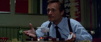 Movie still from “Heartbeeps” (1981), directed by Allan Arkush – A man sitting at a dining table with his arms outstreched; Close Up shot, High angle