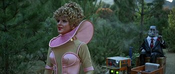 Movie still from “Heartbeeps” (1981), directed by Allan Arkush – A woman in a pink and yellow costume; Medium shot, Low angle