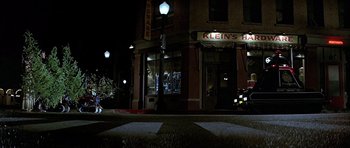 Movie still from “Heartbeeps” (1981), directed by Allan Arkush – A street corner at night with a store front; Wide shot, Low angle