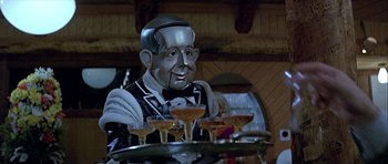 Movie still from “Heartbeeps” (1981), directed by Allan Arkush – A man dressed as a robot holding a tray of drinks; Close Up shot, High angle