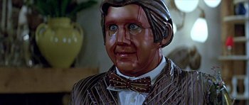 Movie still from “Heartbeeps” (1981), directed by Allan Arkush – A statue of an old man wearing a bow tie; Close Up shot, Over the shoulder angle