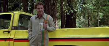 Movie still from “Heartbeeps” (1981), directed by Allan Arkush – A man holding a mug standing in front of a yellow truck; Medium shot, Low angle