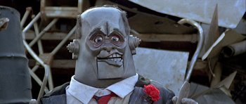 Movie still from “Heartbeeps” (1981), directed by Allan Arkush – A person wearing a suit and tie; Close Up shot, Low angle