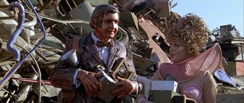 Movie still from “Heartbeeps” (1981), directed by Allan Arkush – A statue of a man holding a pair of knifes; Medium shot, Low angle