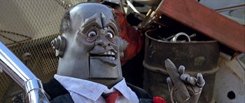 Movie still from “Heartbeeps” (1981), directed by Allan Arkush – The face of a man in a suit and red tie; Extreme Close Up shot, Low angle