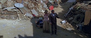 Movie still from “Heartbeeps” (1981), directed by Allan Arkush – A man and a woman standing next to a robot; Wide shot, High angle