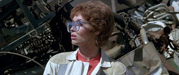 Movie still from “Heartbeeps” (1981), directed by Allan Arkush – A person with glasses and a red shirt is looking at something; Close Up shot, Low angle