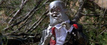 Movie still from “Heartbeeps” (1981), directed by Allan Arkush – A man in a suit and red tie smoking a cigarette; Close Up shot, Low angle