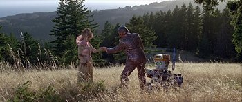 Movie still from “Heartbeeps” (1981), directed by Allan Arkush – A man and a woman dressed in costume shaking hands; Wide shot, Low angle