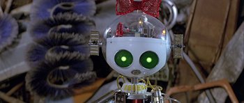 Movie still from “Heartbeeps” (1981), directed by Allan Arkush – A robot with a red bow on it's head; Extreme Close Up shot, High angle