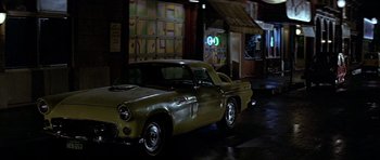 Movie still from “Heartbeeps” (1981), directed by Allan Arkush – An old car parked on the side of the street; Wide shot, High angle