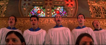 Movie still from “Heartbreakers” (2001), directed by David Mirkin – A group of men standing next to each other in front of a stained glass window; Medium shot, Low angle