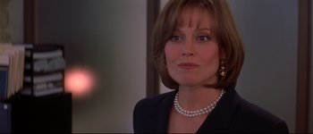Movie still from “Heartbreakers” (2001), directed by David Mirkin – A person wearing a suit and pearls; Close Up shot, Over the shoulder angle