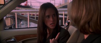 Movie still from “Heartbreakers” (2001), directed by David Mirkin – A woman sitting in the back seat of a car holding a cell phone; Close Up shot, Over the shoulder angle