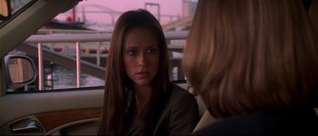 Movie still from “Heartbreakers” (2001), directed by David Mirkin – A woman sitting next to another woman in a car; Close Up shot, Over the shoulder angle