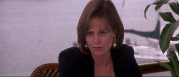 Movie still from “Heartbreakers” (2001), directed by David Mirkin – A person wearing a suit and earrings; Close Up shot, Over the shoulder angle